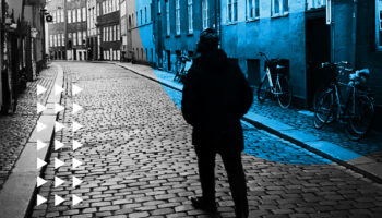 A man walking down a cobblestone street